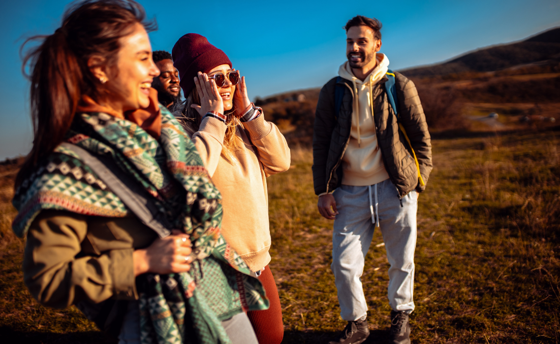 Grupo de amigos com roupas de frio em um espaço aberto aproveitando o sol