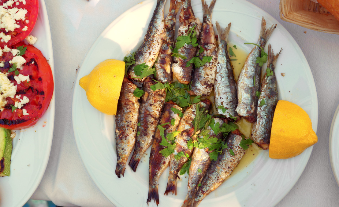 Plato de sardinas a la parrilla con limón y hierbas frescas