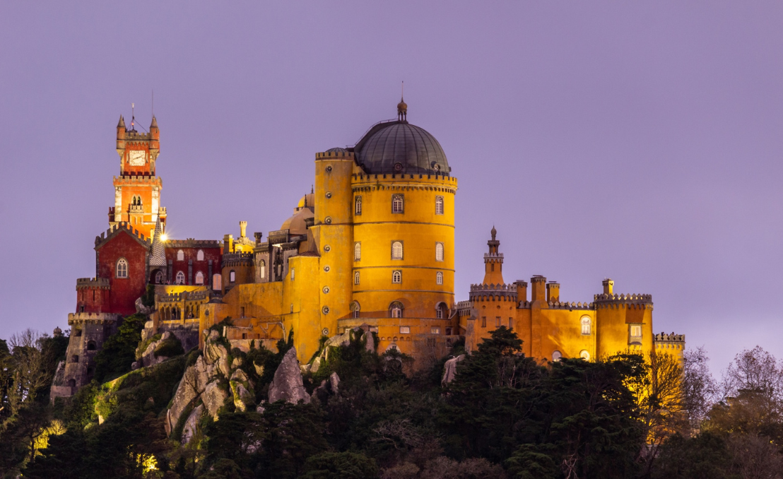 Palácio da Pena iluminado ao entardecer em Sintra