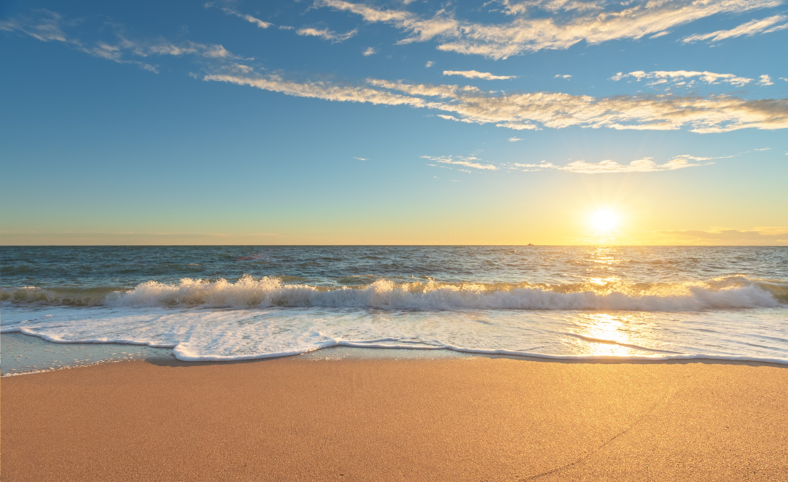 Praia de Porto Novo ao pôr do sol com ondas suaves e céu limpo